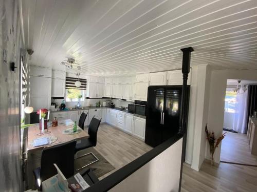 HusumNordic Villa的厨房配有白色橱柜、桌子和冰箱。