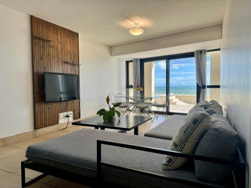 斯特兰德Loddey's Self Catering Apartments - by Beach Collection的带沙发、电视和桌子的客厅