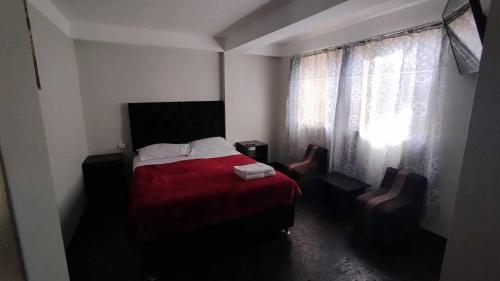 库斯科MEDIA LUNA apart的一间卧室配有红色的床和两把椅子