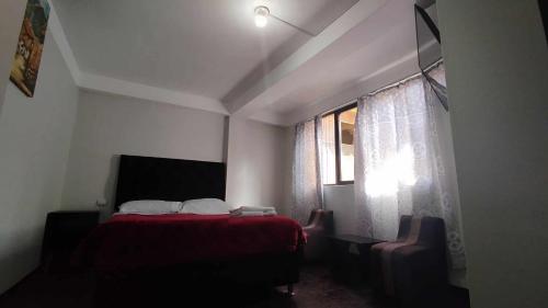 库斯科MEDIA LUNA apart的一间卧室设有红色的床和窗户。
