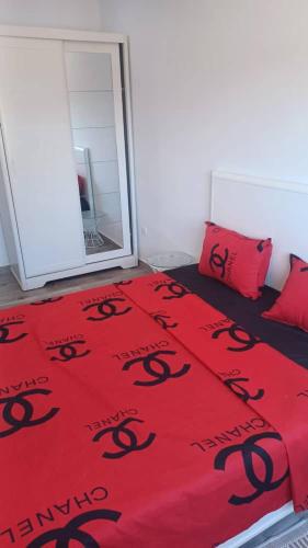 奥兰Fernand ville oran的一间卧室,卧室里配有带黑色蛇的红色毯子