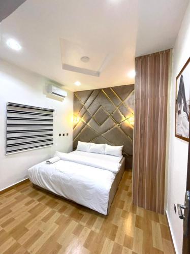 瓦里CEO HOMES AND APARTMENT的卧室配有一张白色的大床,铺有木地板