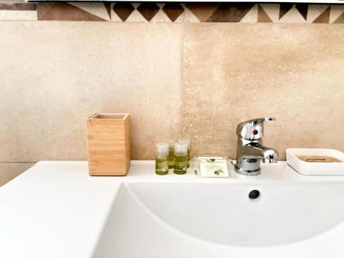 托雷阿马莱San Domenico bed and breakfast的浴室水槽设有水龙头和2个玻璃瓶