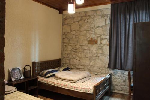 安布罗劳里Royal Edena的石墙房间内的一张床位