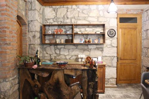 安布罗劳里Royal Edena的厨房设有石墙和木桌