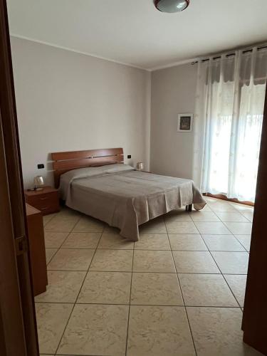 蒙德拉戈内Casa Sofia的卧室配有1张床,铺有瓷砖地板。