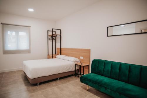 ZaratánPolorooms的一间卧室配有一张床和一张绿色沙发