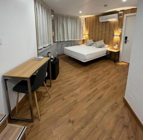 巴塞罗那梅蒂斯酒店的一间卧室配有一张床、一张桌子和一张桌子