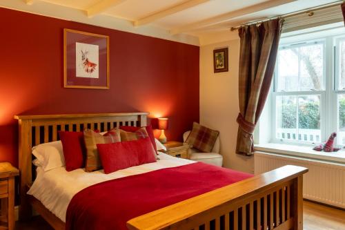 德拉姆纳德罗希特Bridgend House B&B的一间卧室设有一张红色墙壁和窗户的床