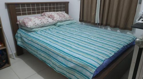 马塞约CASA JARDIM PINHEIROS的一张带蓝色条纹毯子和两个枕头的床