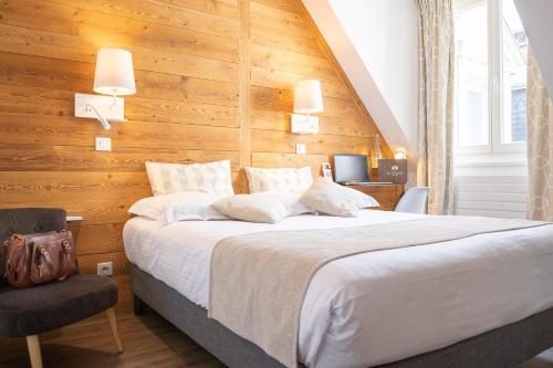 尚贝里Hôtel des Princes, Chambéry Centre的一间卧室设有一张带木墙的大床