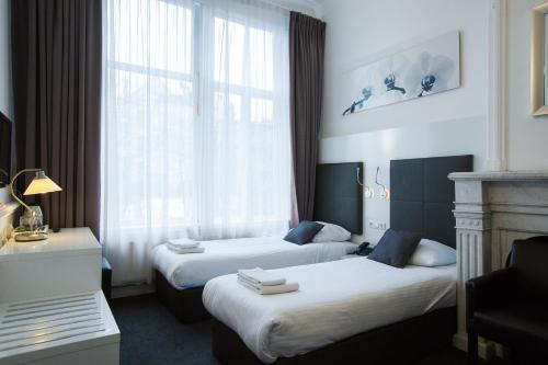 阿姆斯特丹福索冯德尔公园酒店的酒店客房设有两张床和窗户。