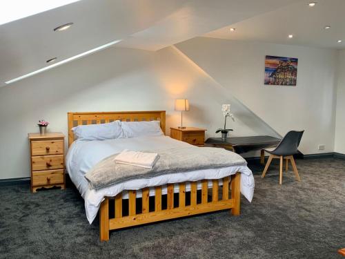 伯明翰Stunning 5 bedroom home families HS2 NEC Airport contactors welcome的一间卧室配有一张床、一张桌子和一把椅子