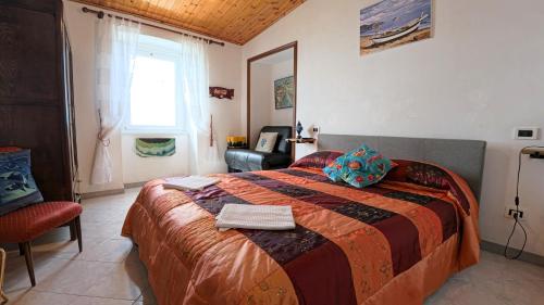 San BernardinoAppartamento Luca e Giulia的一间卧室配有一张大床和一把椅子