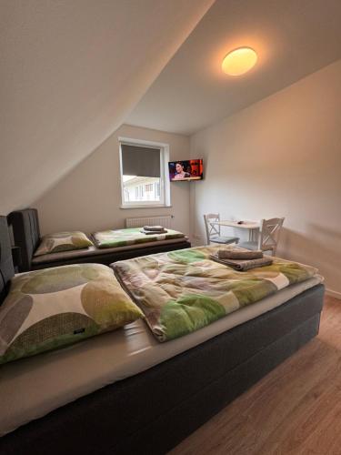 新明斯特Raum fur Ruhe im Norden的一间卧室配有两张床和一张桌子