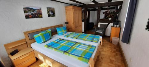 米尔滕贝格Wein-und Gasthof Zipf的一间卧室配有两张带蓝色和绿色枕头的床