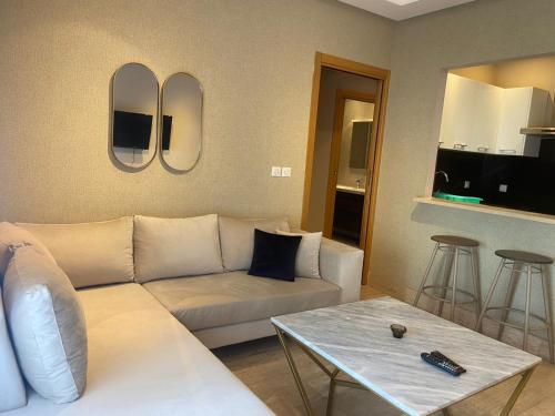 突尼斯Appartement en résidence tunis的客厅配有白色的沙发和桌子