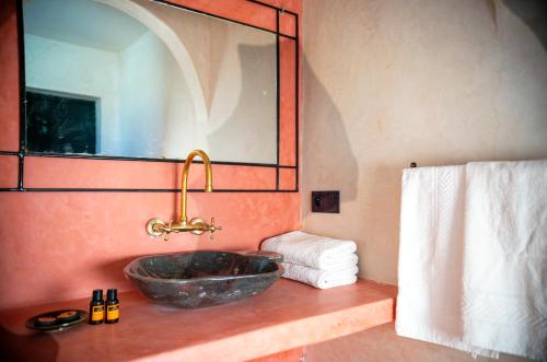 瓦尔扎扎特古堡卡斯巴酒店的一间带石制水槽和镜子的浴室