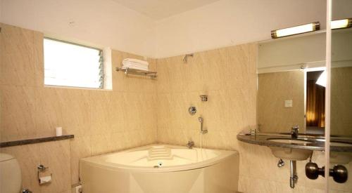 班加罗尔Trinity Suites的带浴缸、盥洗盆和卫生间的浴室