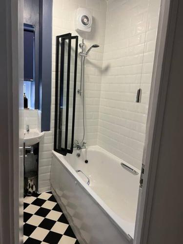 伦敦Flat in White city - Westfield的白色的浴室设有浴缸和水槽。