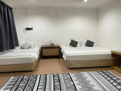 加央#KangaQHomestay99的客房设有两张床和一张边桌
