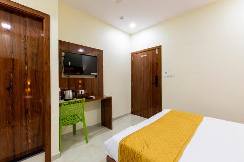 孟买Hotel New Imperial的一间卧室配有一张床、一张书桌和一台电视