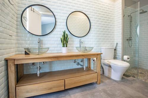 普拉纳维瑙Nearly Oceanfront Blue 3 Bedroom Spacious Villa的一间带两个盥洗盆和卫生间的浴室