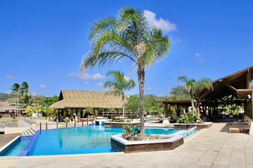 普拉纳维瑙Nearly Oceanfront Blue 3 Bedroom Spacious Villa的游泳池旁的棕榈树