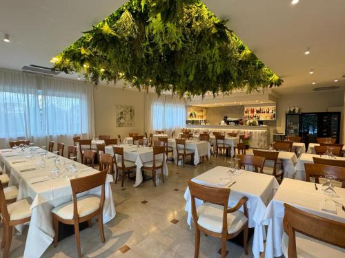 卡斯特努沃德加尔达多里酒店的一间设有白色桌椅的用餐室