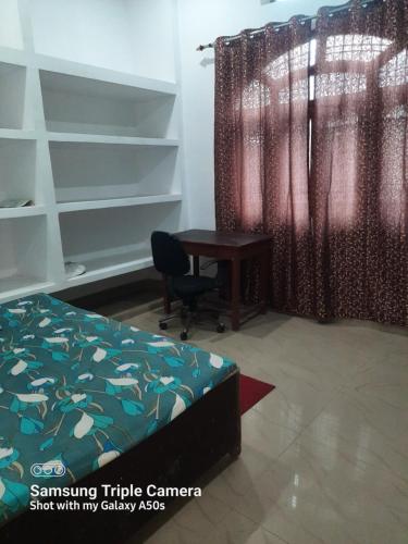 戈勒克布尔Gokul PG Homestay的一间卧室配有书桌、床和窗户。