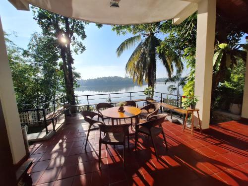 BandaragamaMyHoliday Home @ Bandaragama的阳台配有桌椅,享有水景