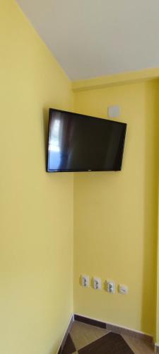 KuršumlijaApartmani Ad fines的挂在黄色墙上的平面电视