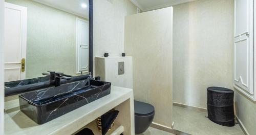 马拉喀什Charming 2-Bed Oasis Pool View的浴室设有黑色水槽和镜子