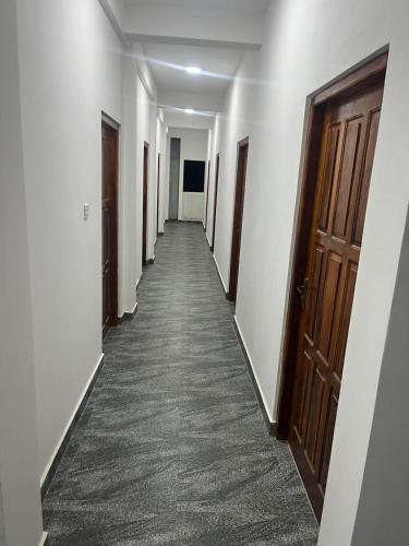 亭可马里Krishna Bhavan Hotel的走廊上的门和地毯的走廊
