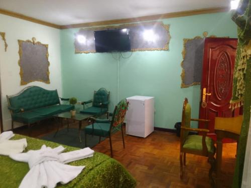 波托西HOTEL SAMARICUSUN的一间设有椅子和墙上电视的房间