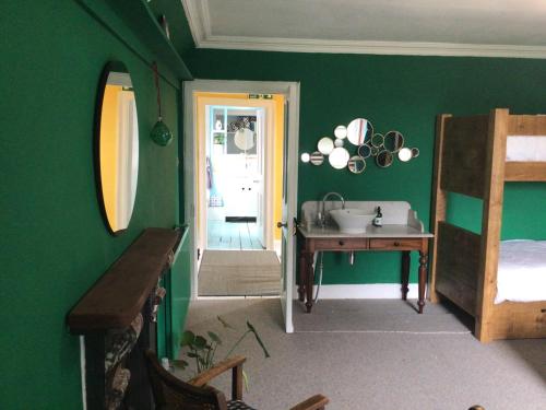 洛克比Mansefield Rooms的一间带水槽的浴室和一间带绿色墙壁的卧室