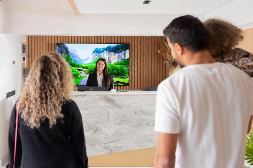 马拉喀什Appart Hôtel Rambla的一群人在电视上观看女人