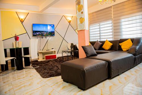雅温得Appartement chic et spacieux près centre Yaoundé的客厅配有真皮沙发和平面电视