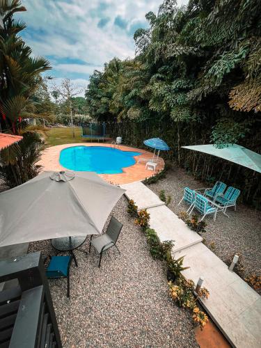 比亚维森西奥Casa hotel Aeroclubr15的一个带遮阳伞和椅子的庭院和一个游泳池