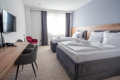 巴尼亚卢卡Hotel Sistems的酒店客房配有两张床和一张书桌