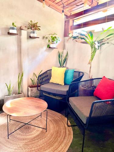 伊斯塔帕Sweet home Ixtapa comfort的庭院配有两把椅子和一张桌子,还有一些植物