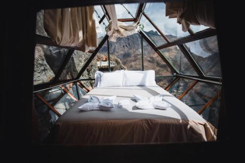 奥兰太坦波Vertical Sky Luxury Suites的玻璃塔中的一个床位房间