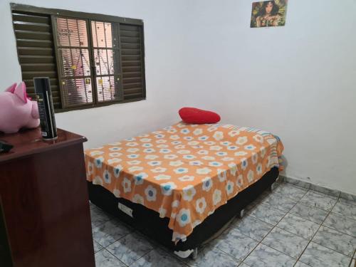 里贝朗普雷托Casa para Temporada Agrishow 2024的一间卧室配有一张带橙色毯子和窗户的床。