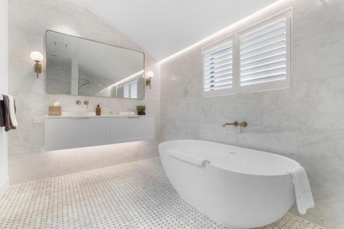 箭镇Arrowtown Mountain Views的白色的浴室设有浴缸和镜子
