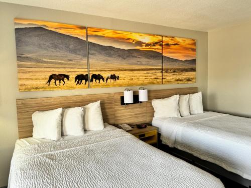 范霍恩范霍恩戴斯酒店的两张床铺,位于酒店客房,墙上挂有绘画作品