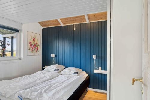 伦德Summer House With Sauna Near Flle Strand,的蓝色墙壁间的一张床位