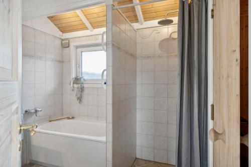 伦德Summer House With Sauna Near Flle Strand,的白色的浴室设有浴缸和淋浴。