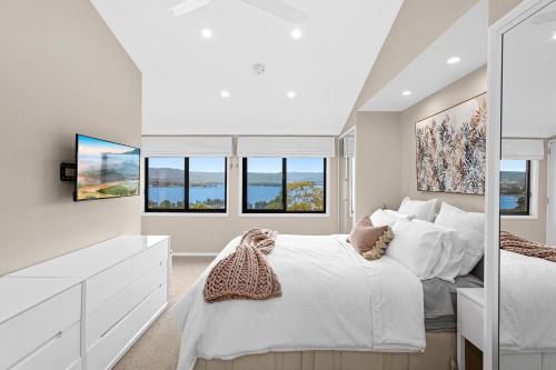 Lake IllawarraHEATed Pool, Lake & Beach, Luxury 5 B/R House的卧室配有白色的床和窗户。