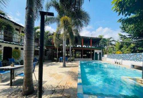 帕洛米诺Hostal Luz de Luna的棕榈树游泳池和大楼