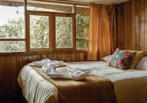 库斯科WARM AND CENTRAL HOUSE WITH SPECTACULAR VIEW OF CUSCO的一间卧室设有一张大床和两个窗户
